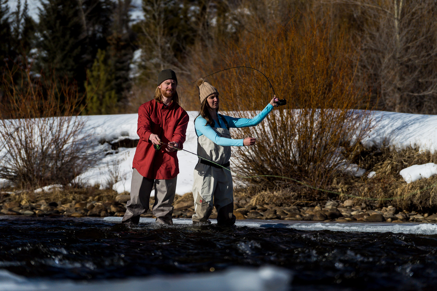 winter colorado engagement photos fly fishing couple casting
