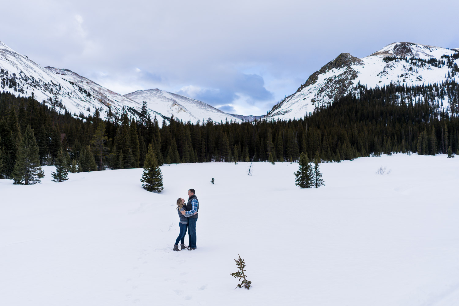 Winter Mountain Engagement Photos walking on snow with big landscape